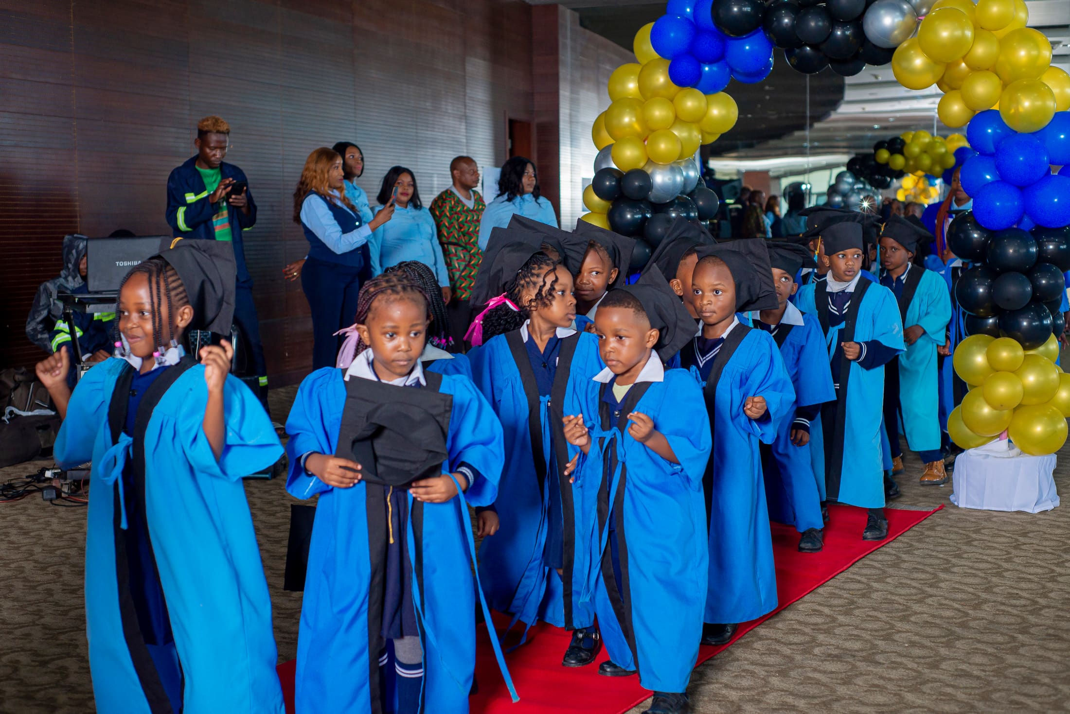 Tukiya graduates walking the red carpet in cap and gown